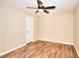 A minimalist bedroom featuring wood-look flooring, a ceiling fan, and neutral paint at 653 Inland Way, Lilburn, GA 30047