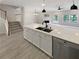Kitchen island with sink and dishwasher overlooking an open floor plan with fireplace at 107 Red Barn Ln, Acworth, GA 30102