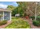 A screened porch overlooks the lovely backyard with mature trees and landscaping at 1119 Simonton Glen Way, Lawrenceville, GA 30045