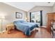Comfortable bedroom with a large window, hardwood floors, and a side table, bathed in natural light at 1119 Simonton Glen Way, Lawrenceville, GA 30045