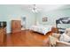 Bright bedroom featuring hardwood floors, a ceiling fan, and a cozy chair with comfortable decor at 1119 Simonton Glen Way, Lawrenceville, GA 30045