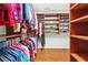 Walk-in closet with custom shelving, shoe racks, and hanging rods for excellent organization with wood flooring at 1119 Simonton Glen Way, Lawrenceville, GA 30045