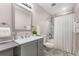 Stylish bathroom featuring marble tile, white shower curtain and a modern vanity with lots of storage at 2831 Spruce Point Rd, South Fulton, GA 30349