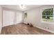 Bright bedroom featuring two windows, ceiling fan, wood-look flooring, and double-door closets at 2831 Spruce Point Rd, South Fulton, GA 30349