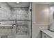 Shower with white and gray tile, glass door and handle bars, with view of vanity at 1037 Martin Rd, Stone Mountain, GA 30088