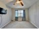 Bedroom features standard ceiling fan, plush carpet, and good natural light and mounted tv at 1037 Martin Rd, Stone Mountain, GA 30088