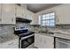 Well-lit kitchen featuring white cabinets, stainless steel appliances, and elegant countertops, creating a functional space at 1037 Martin Rd, Stone Mountain, GA 30088