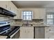 Well-lit kitchen features stone countertops, stainless steel appliances, and white cabinetry at 1037 Martin Rd, Stone Mountain, GA 30088