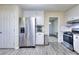 Modern kitchen featuring stainless steel refrigerator, white cabinets, and open view to the entryway at 2493 Cherie Glen Trl, Snellville, GA 30039