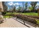 A relaxing wooden back deck overlooks a well-maintained backyard with lush greenery and mature trees at 260 Mansell Cir, Roswell, GA 30075