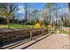 A spacious wooden back deck overlooks a well-maintained backyard, with trees and tiered landscaping at 260 Mansell Cir, Roswell, GA 30075