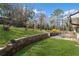 An expansive backyard showcasing tiered landscaping, lush lawn, and a charming deck and patio at 260 Mansell Cir, Roswell, GA 30075