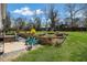 A large backyard features a patio with colorful seating, lush lawn and tiered landscaping at 260 Mansell Cir, Roswell, GA 30075