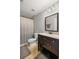 Well-lit bathroom featuring a shower with gray curtains, neutral walls, and a dark wood vanity at 260 Mansell Cir, Roswell, GA 30075