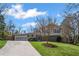 Attractive house with a long driveway, lush green grass, and a beautiful shade tree at 260 Mansell Cir, Roswell, GA 30075