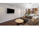 Inviting living room with dark wood floors, brown sectional sofa, and stairs to an open-concept kitchen at 260 Mansell Cir, Roswell, GA 30075