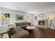 Cozy living room with hardwood floors, a gray sofa, and a fireplace with a decorative mantle at 260 Mansell Cir, Roswell, GA 30075