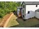 Exterior of home featuring covered back deck, backyard, and retaining wall at 320 Dodd Ln, Alpharetta, GA 30005
