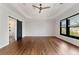 Large bedroom showcasing tray ceiling, hardwood floors, a sliding barn door, and a window at 320 Dodd Ln, Alpharetta, GA 30005