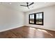 Bright bedroom with hardwood floors, ceiling fan, and a large window offering neighborhood views at 320 Dodd Ln, Alpharetta, GA 30005