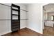 Walk-in closet with custom shelving units and a view into bathroom with tub and shower at 320 Dodd Ln, Alpharetta, GA 30005