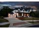 Exterior of home featuring large driveway, three-car garage, and meticulous landscaping at 320 Dodd Ln, Alpharetta, GA 30005