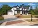 Stunning new home showcasing a black roof, white facade, green grass, and ample parking at 320 Dodd Ln, Alpharetta, GA 30005