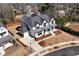 New construction home featuring white siding, black trim, a covered porch, and a two-car garage at 320 Dodd Ln, Alpharetta, GA 30005