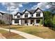 Charming new construction featuring a manicured lawn, sidewalk, and a striking white exterior at 320 Dodd Ln, Alpharetta, GA 30005