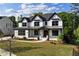 New construction home with manicured lawn featuring black trim and white siding under a blue sky at 320 Dodd Ln, Alpharetta, GA 30005