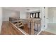 Second floor hallway with hardwood floors, black metal railing, and bright light fixture at 320 Dodd Ln, Alpharetta, GA 30005