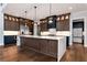 Bright kitchen features a central island, stainless steel appliances, custom cabinets, and white countertops at 320 Dodd Ln, Alpharetta, GA 30005