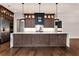 Elegant kitchen island with white countertop, stylish pendant lighting, seating for six, and custom wood cabinets at 320 Dodd Ln, Alpharetta, GA 30005