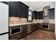 Modern kitchen features stainless appliances, dark cabinets and a tile backsplash at 320 Dodd Ln, Alpharetta, GA 30005