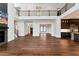 Open-concept living space with hardwood floors, fireplace, and a view into a modern kitchen with large island at 320 Dodd Ln, Alpharetta, GA 30005