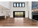 Spacious living room with hardwood floors, a modern fireplace, and access to an outdoor deck and kitchen at 320 Dodd Ln, Alpharetta, GA 30005