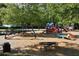 Image features a colorful playground with slides and climbers set amidst a wood chip safety surface and mature trees at 320 Dodd Ln, Alpharetta, GA 30005