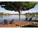 Stunning waterfront view with adirondack chairs under a mature tree, perfect for relaxation at 320 Dodd Ln, Alpharetta, GA 30005