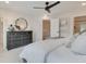 Serene main bedroom featuring a dark dresser, neutral decor, ceiling fan and an open doorway to an ensuite bathroom at 4814 Floydwood Ln, Mableton, GA 30126