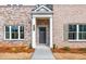 Charming brick townhome entrance with a stylish door, well-lit porch, and neatly landscaped surroundings at 4814 Floydwood Ln, Mableton, GA 30126