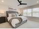 A serene main bedroom showcasing a tufted headboard, ceiling fan, and ample natural light at 4814 Floydwood Ln, Mableton, GA 30126