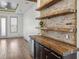 Stylish bar area with brick accent wall, wooden shelves, and built-in wine fridge at 560 John Wesley Dobbs Ave, Atlanta, GA 30312
