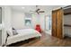 Cozy bedroom with hardwood floors, a ceiling fan, and a rustic wood sliding barn door to the closet at 560 John Wesley Dobbs Ave, Atlanta, GA 30312
