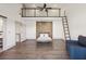 Open bedroom with hardwood floors, wooden accent wall, a ladder, and upper level at 560 John Wesley Dobbs Ave, Atlanta, GA 30312