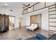 Open bedroom with hardwood floors, wooden accent wall, a fireplace, a ladder, and upper level at 560 John Wesley Dobbs Ave, Atlanta, GA 30312