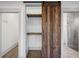 Open closet with custom shelving and a rustic wooden sliding barn door, providing ample storage space at 560 John Wesley Dobbs Ave, Atlanta, GA 30312