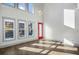 Bright living room with large windows, wood floors, and a red door leading to the entryway at 560 John Wesley Dobbs Ave, Atlanta, GA 30312