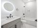 Bathroom featuring gray vanity, white countertop, round LED mirror, and tub/shower combo with black fixtures at 2195 Springdale Sw Rd, Atlanta, GA 30315