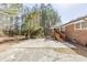 The backyard shows the brick home exterior, patio and lawn with mature trees at 3435 Macland Rd, Powder Springs, GA 30127