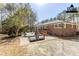 Staged backyard with patio, outdoor furniture, brick home exterior, and mature trees at 3435 Macland Rd, Powder Springs, GA 30127